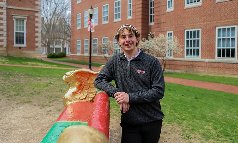 Austin Pickett smiles towards the camera seated on the senior bench.